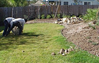 The above picture shows several workers moving a rock into the proper place in the landscape.