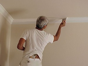 The painter applies a final coat to the crown molding.